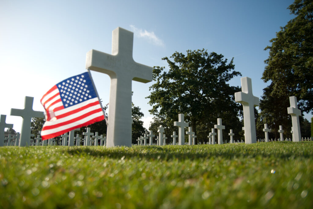 Cross and flag at the American Cemetary in Normandy France.